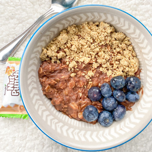 Nut bar crumbled over yogurt with blueberries for a healthy plant-based breakfast