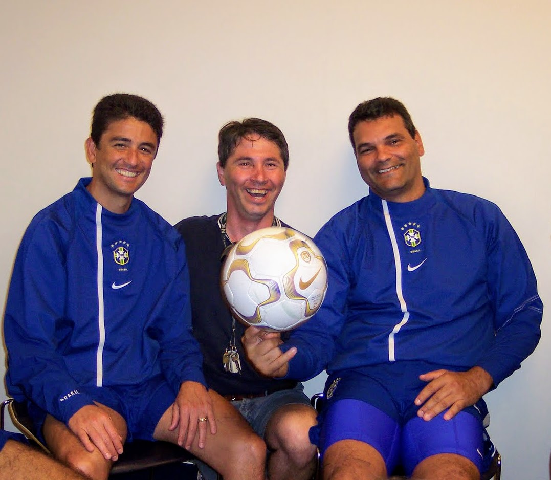 TerraNut co-founder and former professional athlete Ed Bifulco smiles in the center while pointing to a Nike soccer ball, flanked by legendary Brazilian World Cup champion Bebeto on the left and Ricardo Silva on the right